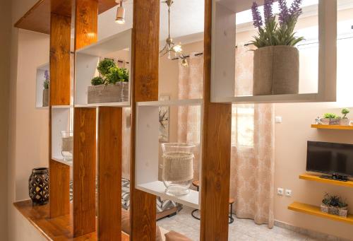 a room with wooden walls and shelves with plants at Chrysa Apartment in Makrýgialos