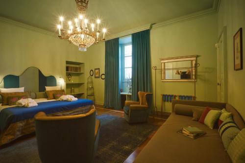 a bedroom with a bed and a couch and a chandelier at Look To in Turin