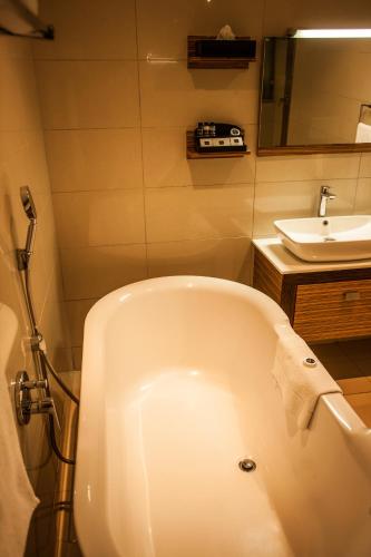 a white bath tub in a bathroom with a sink at Coastlands Umhlanga Hotel and Convention Centre in Durban
