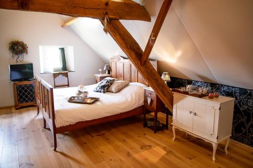 1 dormitorio con 1 cama y TV en el ático en B&B La Rue de France, en Sevenum