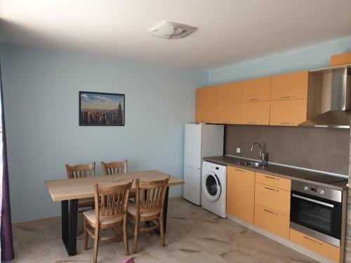 a kitchen with a table and chairs and a sink and a stove at Hiora Apartments Vasiliko in Tsarevo