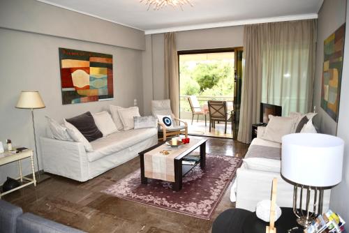 a living room with a white couch and a table at Amazing Apartment in Athens