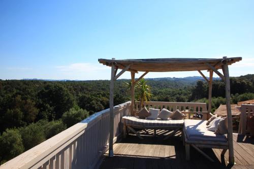 a wooden deck with a bed and a gazebo at MORF suites in Casale Marittimo