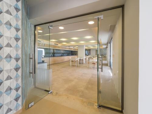 a glass door leading to a dining room with tables at Paradise Resort in Finikounta