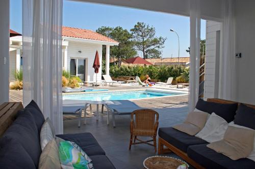 a living room with a couch and a swimming pool at Côte et Dune in Biscarrosse-Plage