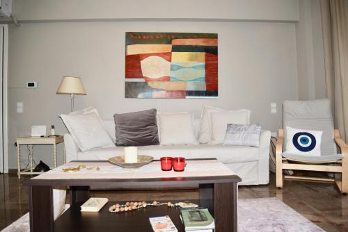 a living room with a white couch and a table at Amazing Apartment in Athens