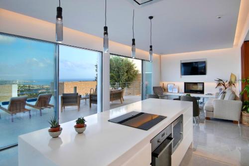 a kitchen and living room with large glass windows at Elea Silver Villa in Peyia