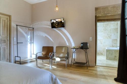 een slaapkamer met 2 stoelen en een kamer met een bed bij Le Château de Camille in Saint-Jean-le-Comtal