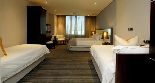 a hotel room with two beds and a desk at Coastlands Umhlanga Hotel and Convention Centre in Durban