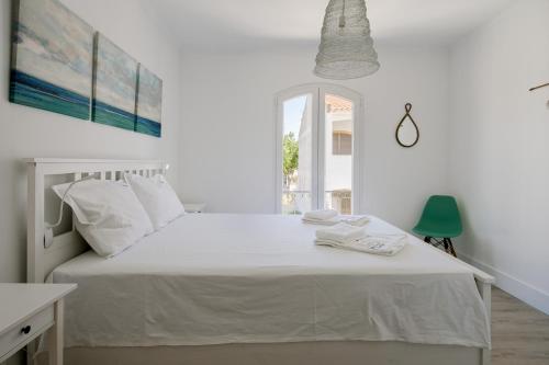 a white bedroom with a white bed and a window at FLH Altura Family House with Pool in Altura