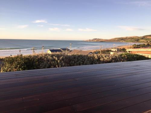 a view of the beach from the roof of a house at Kaka Point Views Apartment 1 in Kaka Point