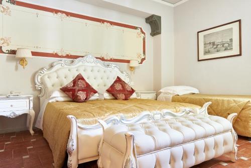 a bedroom with a large white bed with red pillows at Villa Royal in Florence