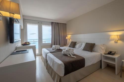 una habitación de hotel con una cama con un perro. en Hotel Rosamar Maxim 4*- Adults Only, en Lloret de Mar