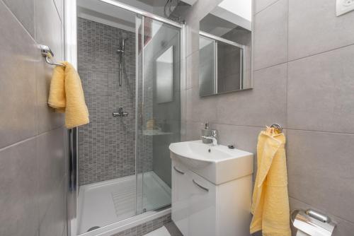 a bathroom with a shower and a sink and a toilet at Tonka Apartments in Gradac