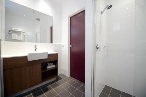 
a bathroom with a sink, toilet, and shower at Grosvenor Hotel Adelaide in Adelaide
