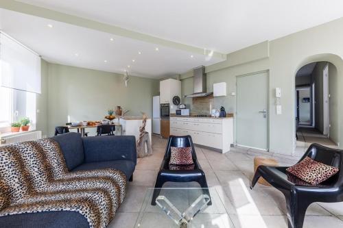 un salon avec un canapé et des chaises et une cuisine dans l'établissement Le Protis, à Marseille