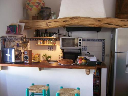 a kitchen with a counter with a microwave and a refrigerator at Hosteria Villa Cardon in Cachí