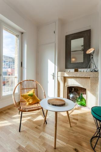 - un salon avec une table, une chaise et une cheminée dans l'établissement Le Minot - Magnifique vue port, à Marseille