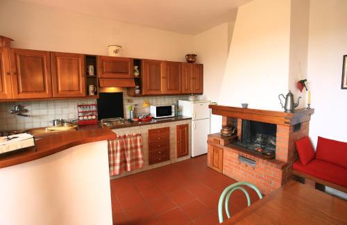 a kitchen with wooden cabinets and a fireplace at Casa Milena in San Gimignano