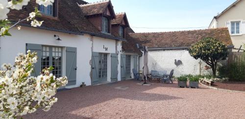 a courtyard of a house with a bench in front of it at Chambre d'hote Chez Liz in Maslives