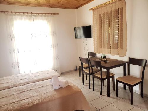 um quarto com uma mesa, cadeiras e uma cama em Marketos Apartments em Svoronata