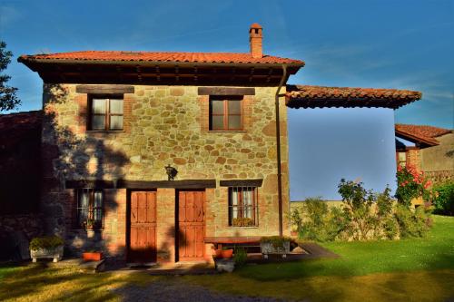 an old stone house with a large door and windows at La Cabada in Ortiguero