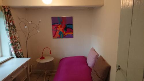 a bedroom with a purple bed and a table at B&B Hesselbjerg in Hesselbjerg