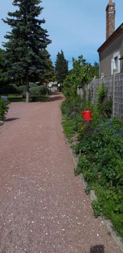 a gravel path next to a house and a tree at Chambre d'hote Chez Liz in Maslives