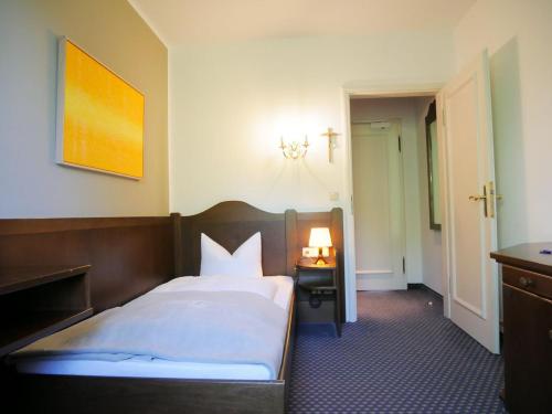 a bedroom with a bed and a table with a lamp at Stadthaus Valentin in Altötting