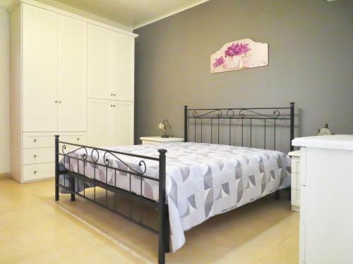 um quarto com uma cama em preto e branco e uma parede em Casa Vacanze Donna Lucia em Scoglitti