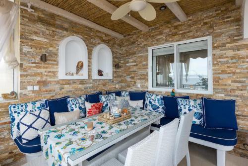 a dining room with a table and blue chairs at Ammos Lux Apartments in Agia Triada