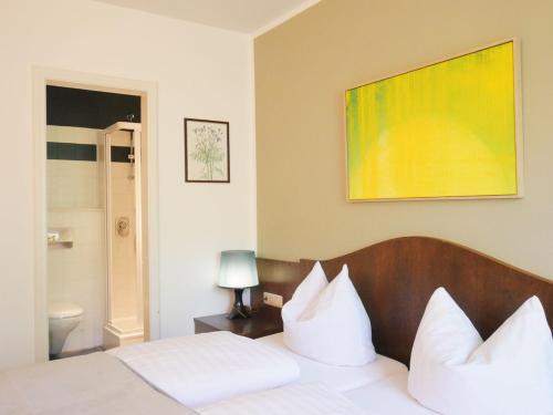 a bedroom with a bed with white pillows at Stadthaus Valentin in Altötting