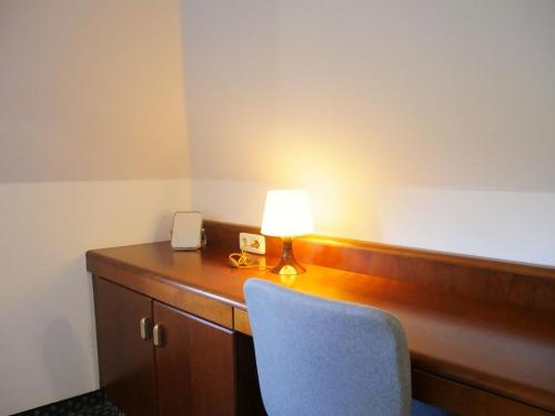 a room with a desk with a lamp and a chair at Stadthaus Valentin in Altötting