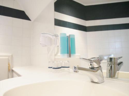 a bathroom sink with a toothbrush holder and a toothbrush holderocument at Stadthaus Valentin in Altötting