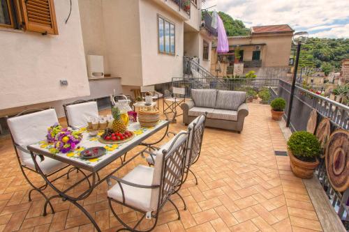 a patio with a table and chairs on a balcony at B&B Carol in Cetara