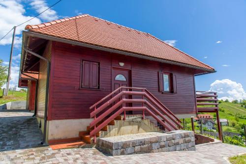 uma pequena casa vermelha com uma escada vermelha no exterior em Brunarica Čontoš em Lendava