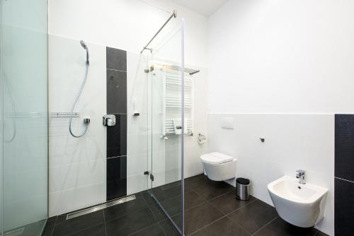 a bathroom with a shower and a toilet and a sink at Karoly Corner Residences in Budapest