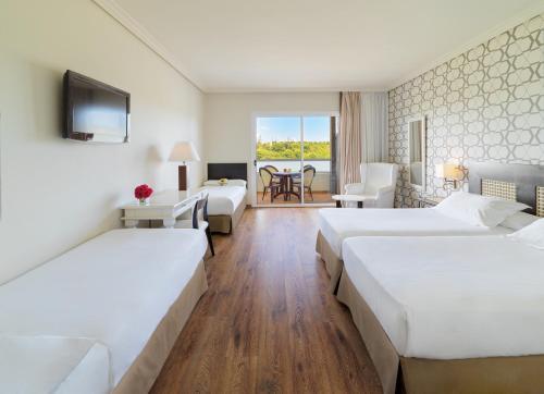 a hotel room with two beds and a television at H10 Salauris Palace in Salou
