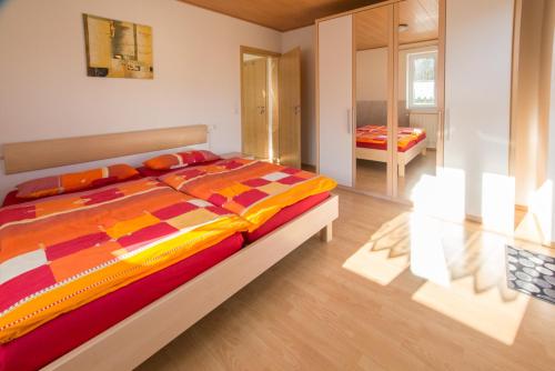 - une chambre avec un lit et une couette colorée dans l'établissement Ferienhaus Regina, à Walkertshofen