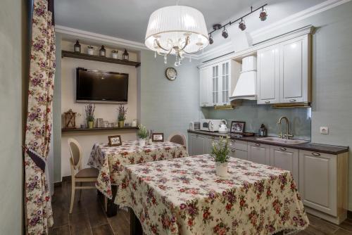 uma cozinha com 2 mesas de jantar e uma cozinha com um lavatório em Bon Son Hotel and Hostel Центр em Voronezh