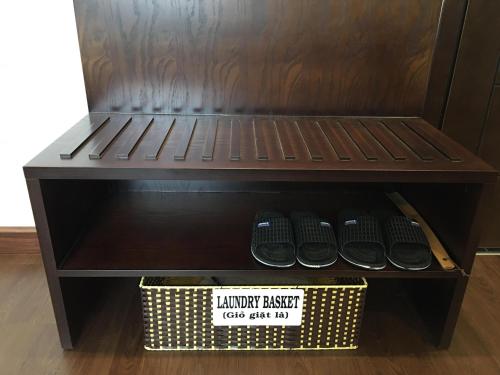 a shelf with a basket and some shoes on it at T&M Luxury Hotel Hanoi in Hanoi