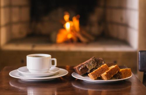 Una taza de café y dos trozos de tarta en una mesa. en Hotel Guaíba, en Guaíba