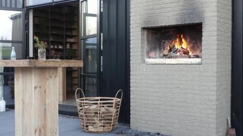 a fireplace on the side of a building with a bench at Vakantiehuizen 7Huizen aan Zee in Scharendijke
