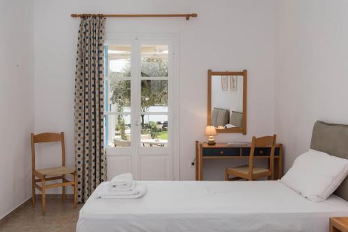 a bedroom with a bed and a mirror and a window at Agrilia Apartments & Studios in Vathi