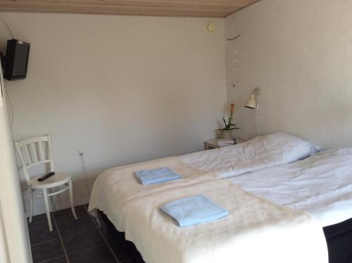 een slaapkamer met een bed met twee handdoeken erop bij Strandværelserne in Ebeltoft