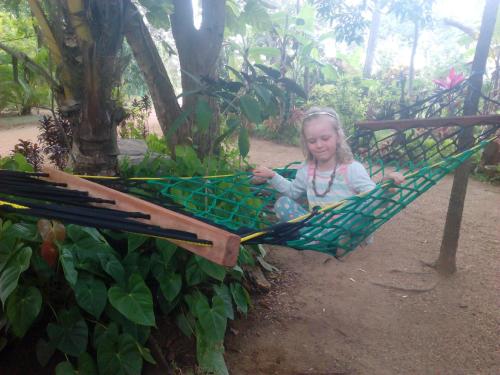 a little girl is sitting in a hammock at Amba Sewana Homestay in Sigiriya