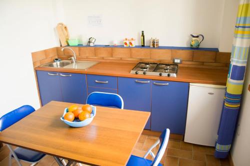 a kitchen with a table with a bowl of oranges on it at Makara Case Vacanza in Eraclea Minoa