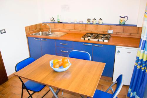 a kitchen with a table with a bowl of oranges on it at Makara Case Vacanza in Eraclea Minoa