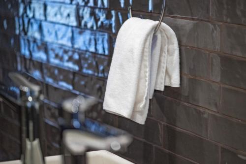a bathroom with a white towel hanging on a wall at Warm House Apart Hotel in Almaty