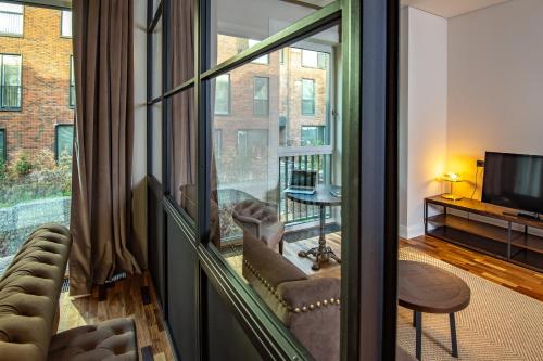 a living room with a large window and a television at Warm House Apart Hotel in Almaty